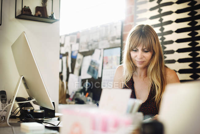 Жінка сидить в офісі за столом — стокове фото