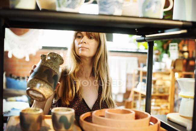Femme tenant un petit vase en céramique . — Photo de stock