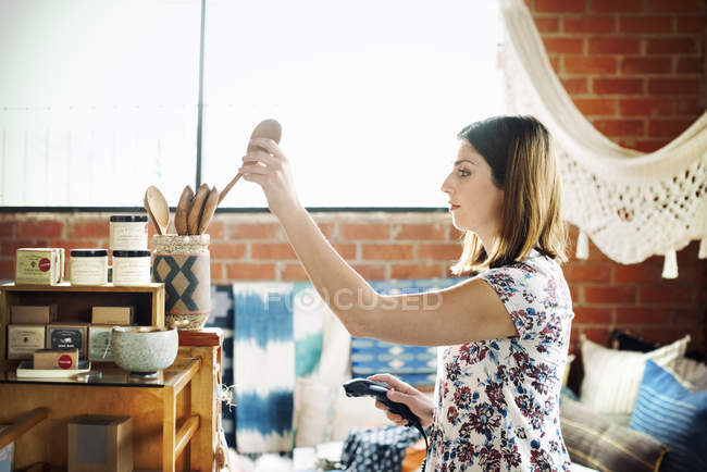 Mulher colocando uma colher de madeira em um frasco — Fotografia de Stock