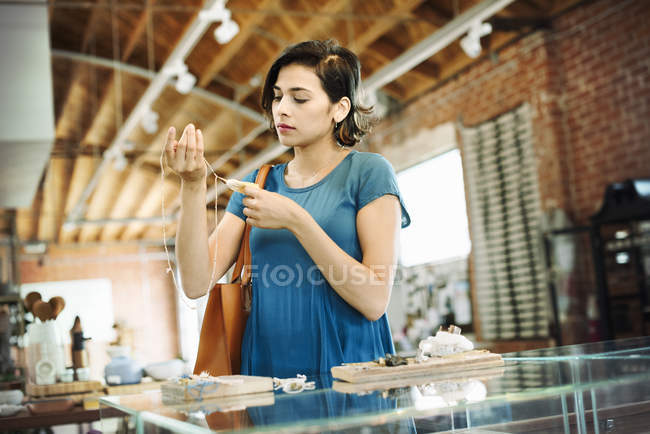 Молода жінка дивиться на намисто . — стокове фото