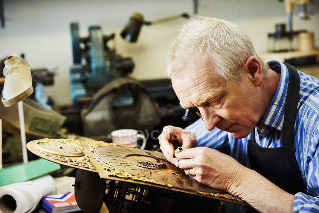 Clockmaker working in his studio — Stock Photo