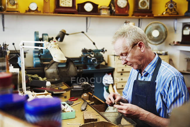 Relojero trabajando en su estudio - foto de stock