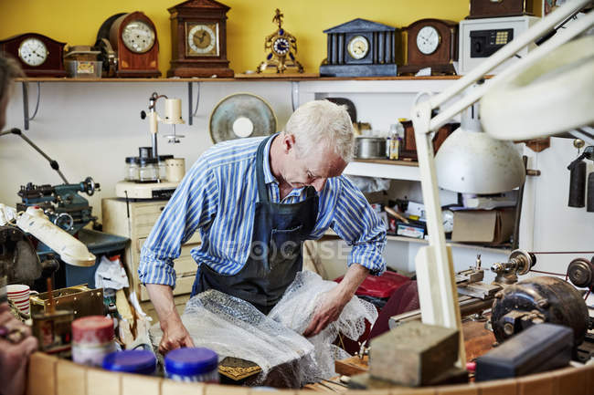 Clockmaker busy in his workshop. — Stock Photo
