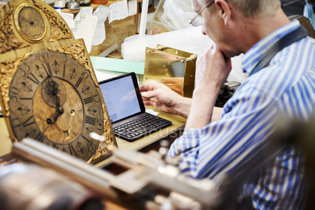 Clock maker in his workshop — Stock Photo