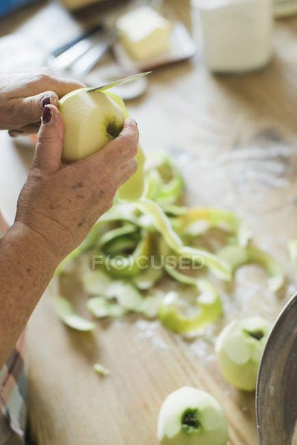 Frau schält einen Apfel. — Stockfoto