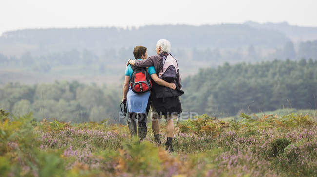 Casal olhando para a vista sobre colinas arborizadas — Fotografia de Stock