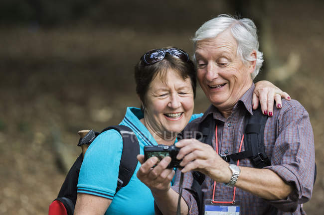 Couple regardant un appareil photo numérique — Photo de stock