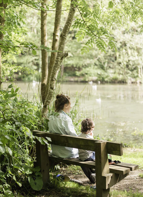 Femme et enfant assis sur un banc . — Photo de stock