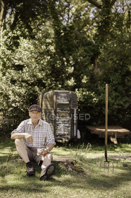 Мужчина сидит в саду . — стоковое фото