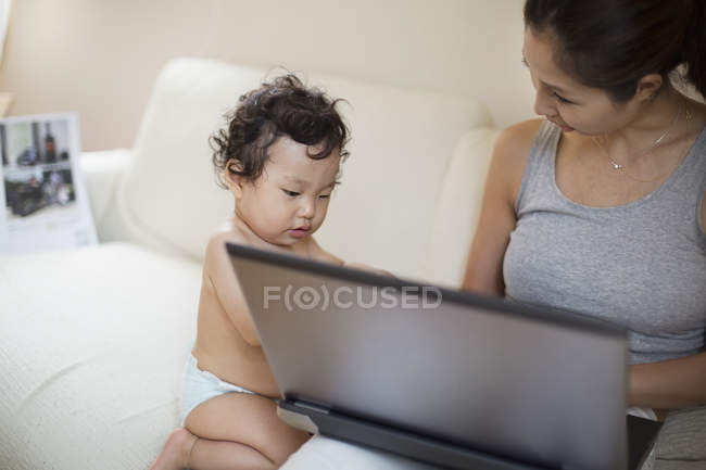 Madre e hijo usando computadora - foto de stock