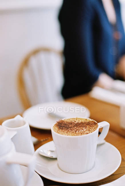 Woman seated at a table — Stock Photo