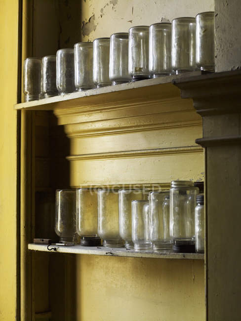 Estantes que almacenan frascos de vidrio volteados - foto de stock