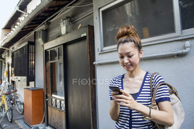 Frau schaut aufs Handy. — Stockfoto