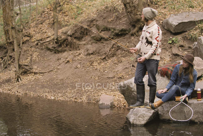 Giovane coppia pesca in un fiume . — Foto stock