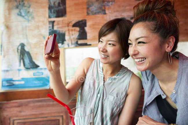 Японские женщины смотрят на сотовый телефон — стоковое фото