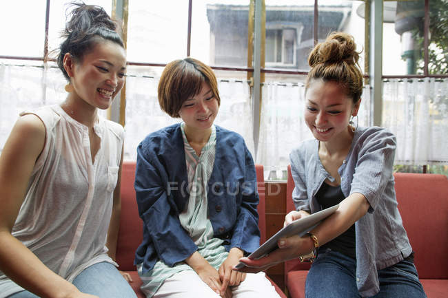 Drei Frauen schauen auf ein digitales Tablet — Stockfoto