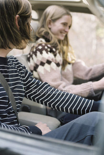 Jeune couple conduisant dans leur voiture . — Photo de stock