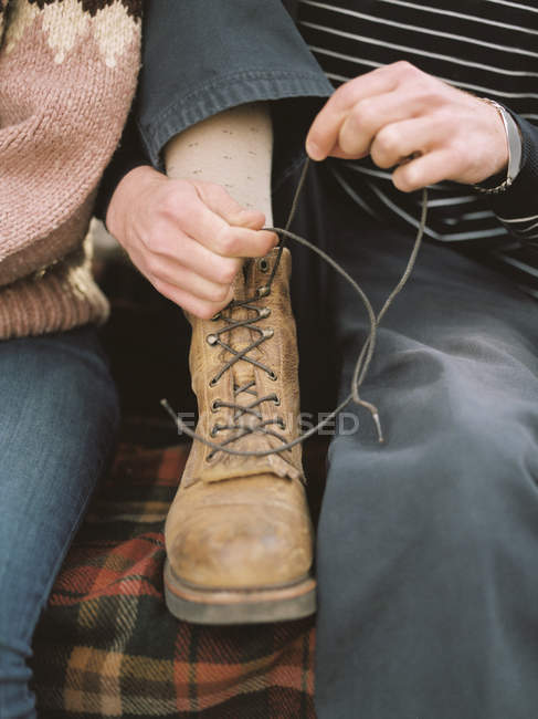 Homem amarrando seus laços de bota — Fotografia de Stock