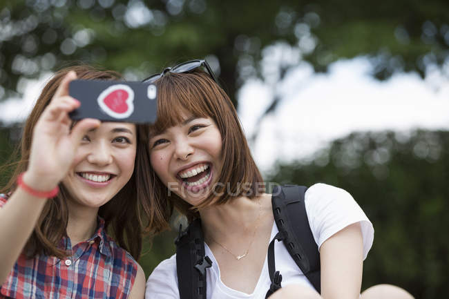 Japanische Freunde machen ein Selfie im Park. — Stockfoto