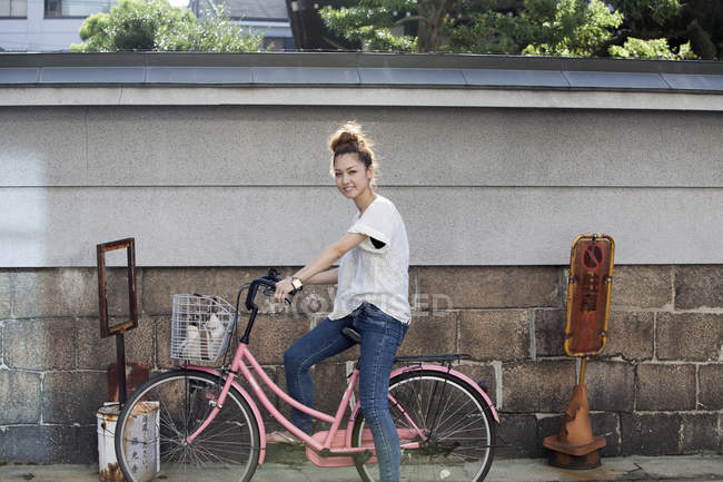 Donna seduta su una bicicletta . — Foto stock