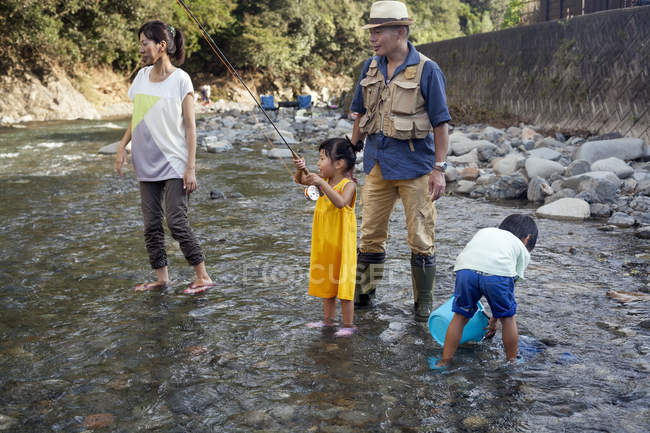 Japanese Family fishing in a stream. — Stock Photo