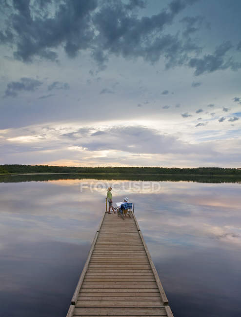 Man and woman on long wooden dock — Stock Photo