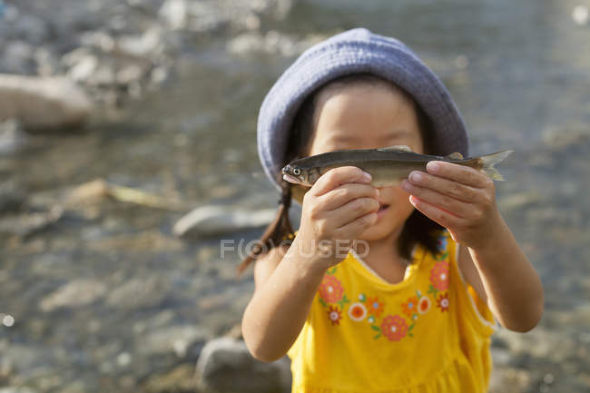 Giovane ragazza in possesso di un pesce . — Foto stock