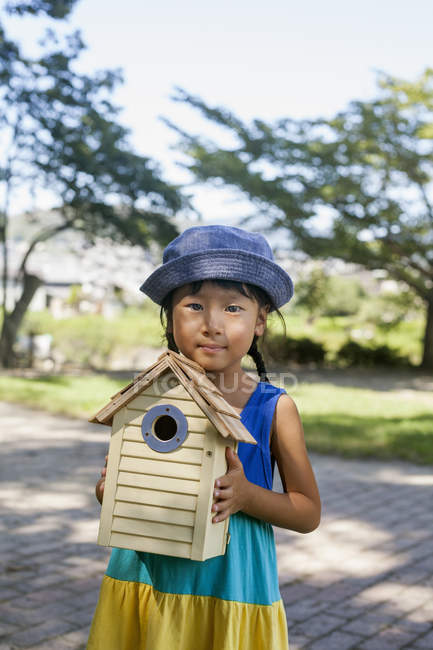 Menina japonesa segurando uma casa de pássaro
. — Fotografia de Stock