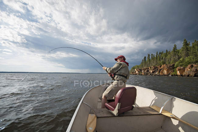 Hombre pescando desde un barco - foto de stock