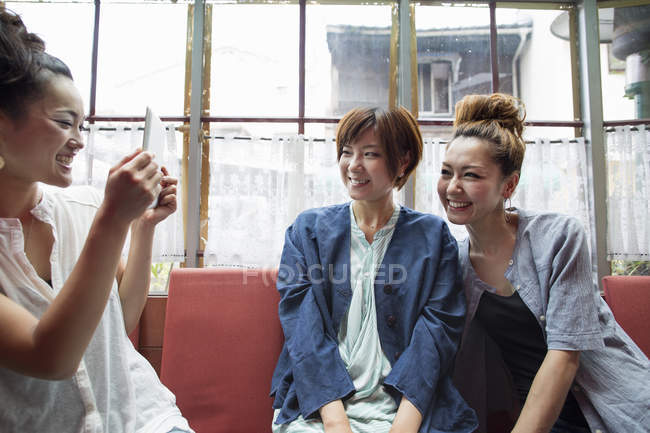 Três mulheres sentadas dentro de casa — Fotografia de Stock