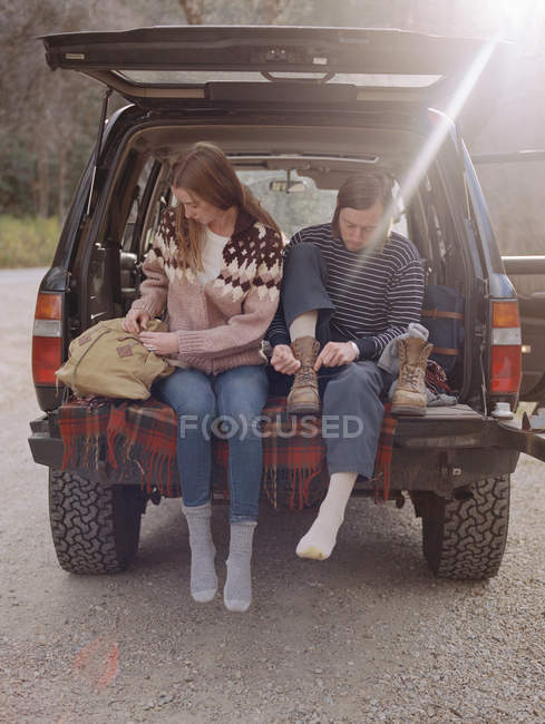 Casal sentado na parte de trás de seu carro — Fotografia de Stock