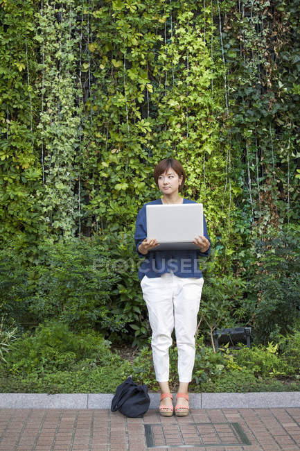 Mujer sosteniendo un portátil - foto de stock