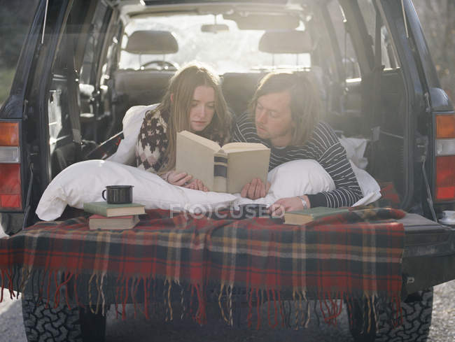 Paar liegt auf dem Rücksitz seines Autos — Stockfoto