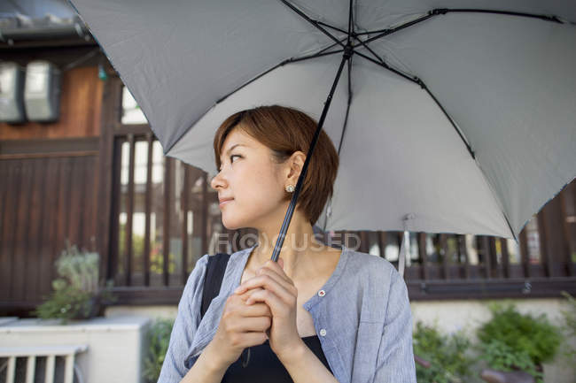 Donna con un ombrello in mano. — Foto stock