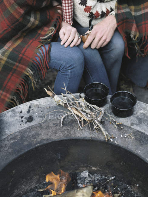 Casal sentado perto de uma fogueira — Fotografia de Stock