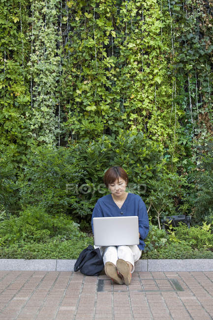 Mujer asiática con un portátil - foto de stock