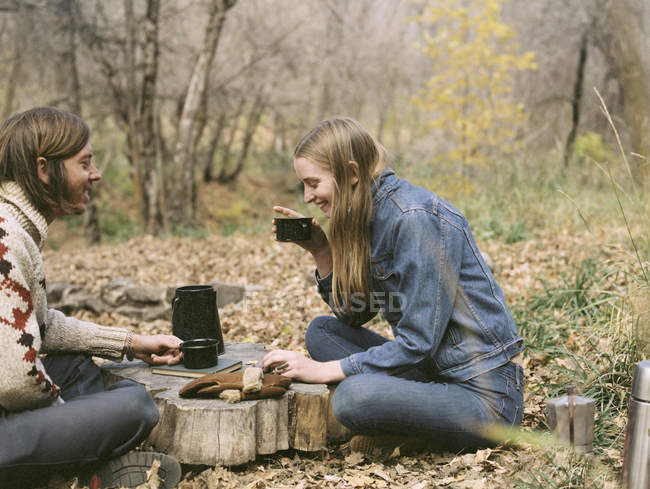 Усміхнена пара сидить у лісі — стокове фото