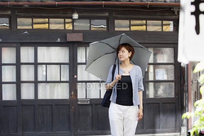 Mujer sosteniendo un paraguas. - foto de stock