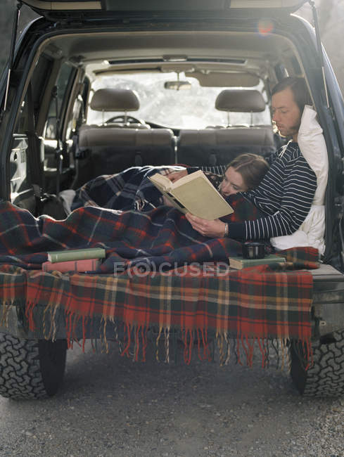 Casal deitado na parte de trás de seu carro — Fotografia de Stock