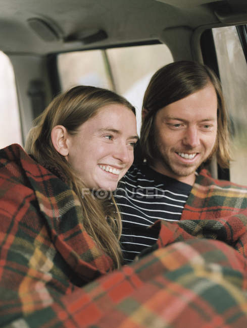 Sonriente pareja sentado en su coche - foto de stock
