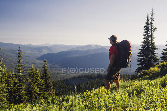 Hombre mochilero en las montañas - foto de stock