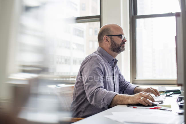 Homem no escritório usando um computador — Fotografia de Stock
