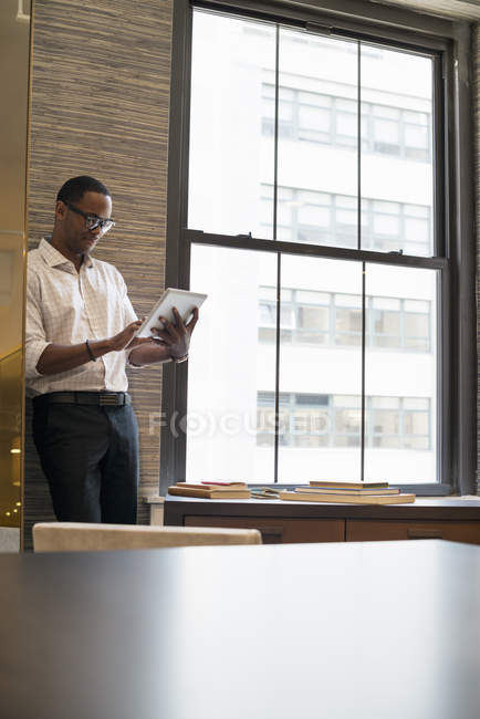 Uomo afroamericano utilizzando un tablet digitale . — Foto stock