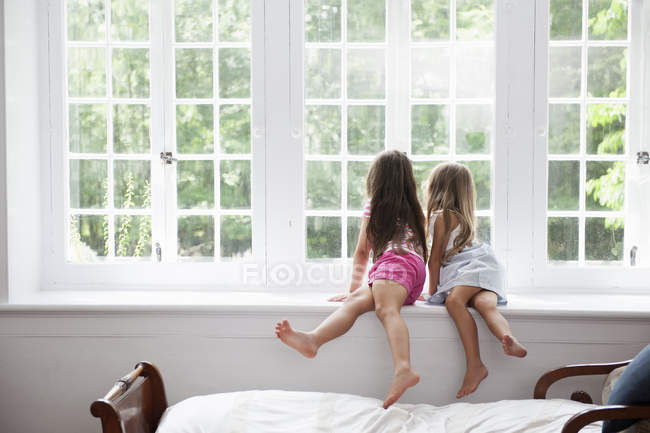 Девушки сидят бок о бок — стоковое фото