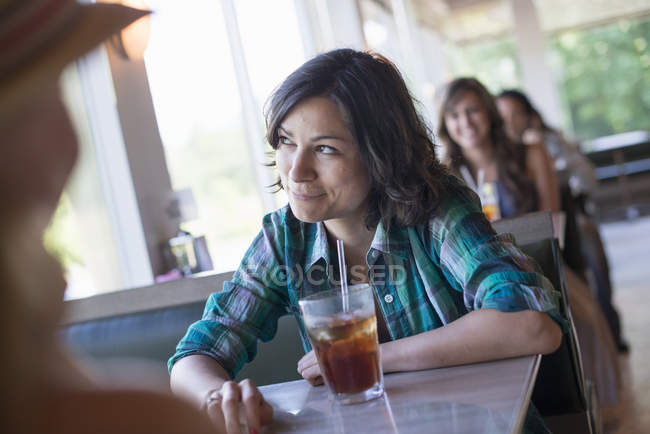 Mulher sentada em um restaurante olhando pela janela — Fotografia de Stock