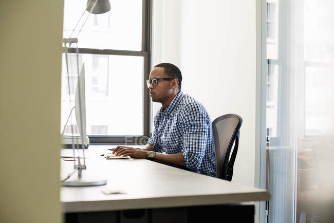 Hombre afroamericano usando una computadora - foto de stock