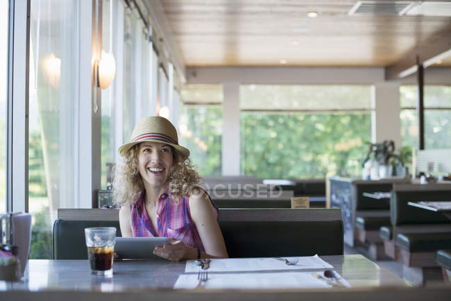 Жінка тримає цифровий планшет у їдальні — стокове фото