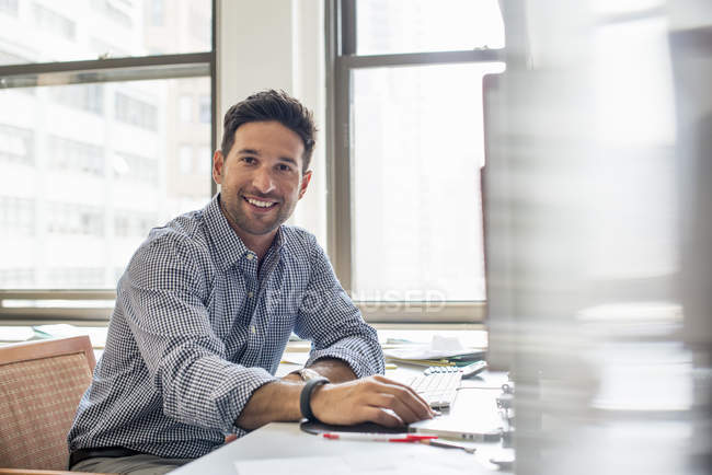 Людина в офісі за допомогою комп'ютера — стокове фото