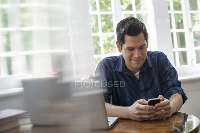 Чоловік перевіряє свій смартфон — стокове фото