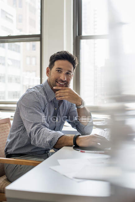 Man sitting at a desk looking at the camera. — Stock Photo